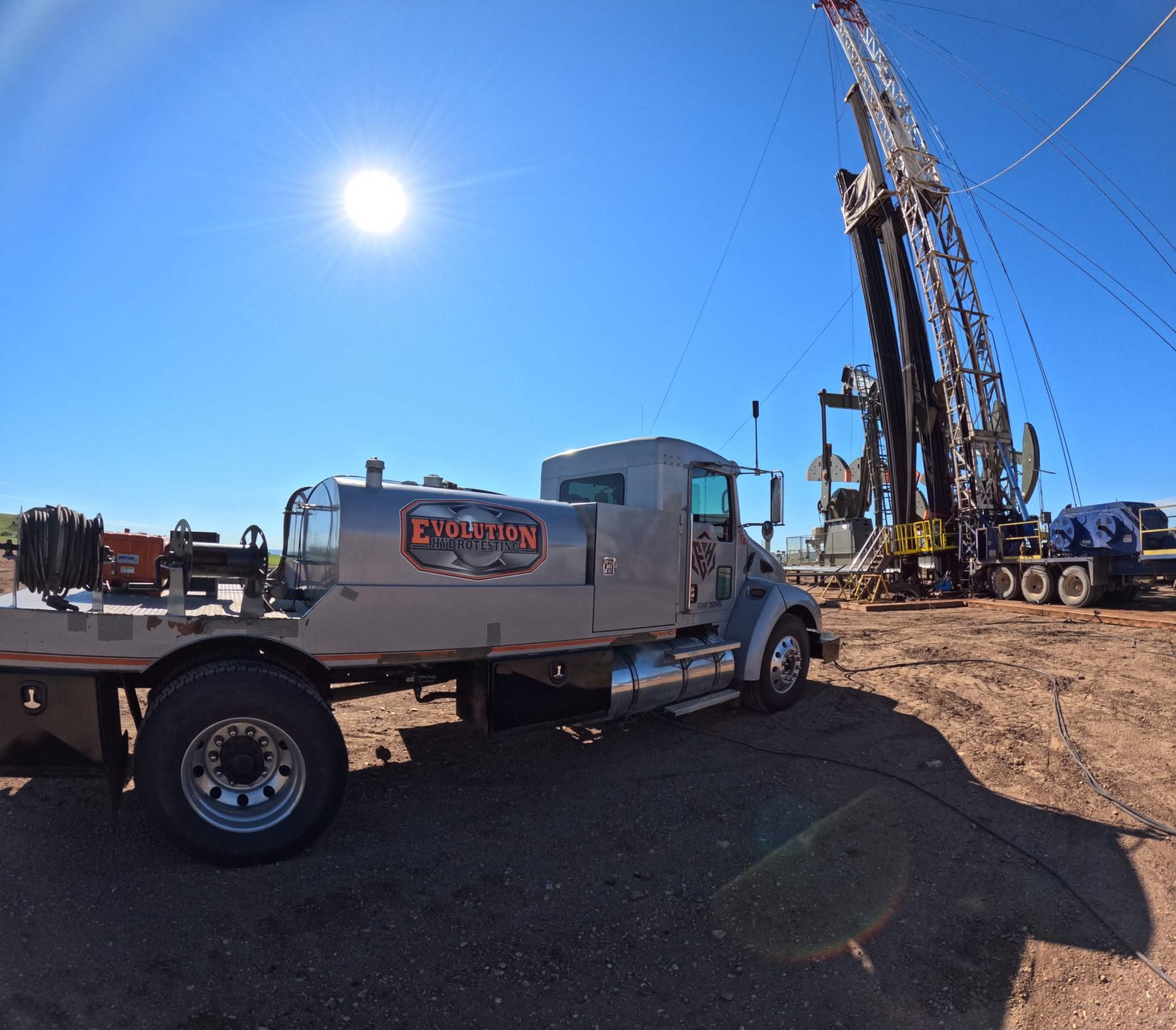 Evolution Hydrotesting support truck working beside a drilling rig in the Bakken region